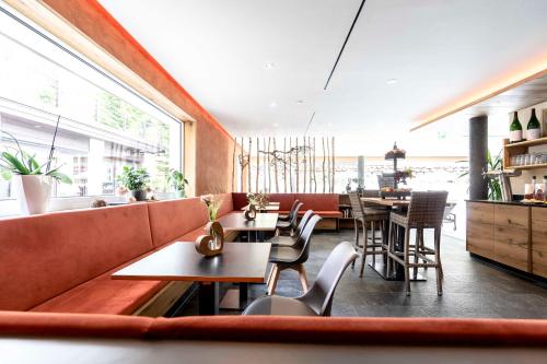 a restaurant with tables and chairs and a large window at Hotel Restaurant Waldsägmühle in Pfalzgrafenweiler