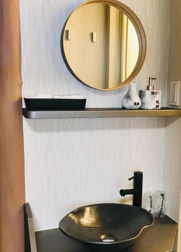 La salle de bains est pourvue d'un lavabo en bronze et d'un miroir. dans l'établissement Daigo - Vacation STAY 04946v, à Kanayama