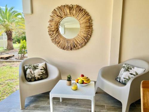 sala de estar con 2 sillas y espejo en Maracuja 6, Orient Bay village, walkable beach at 100m, en Orient Bay