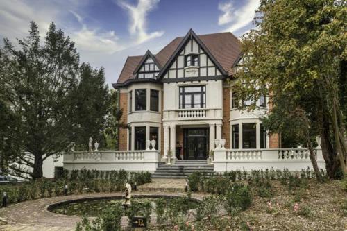 a large white house with a porch and a yard at Fiertelmeers Boutique B&B in Ronse