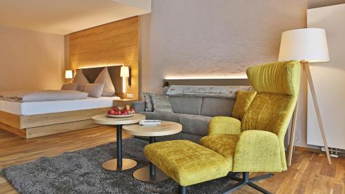 a living room with a couch and a bed at Hotel Restaurant Waldsägmühle in Pfalzgrafenweiler