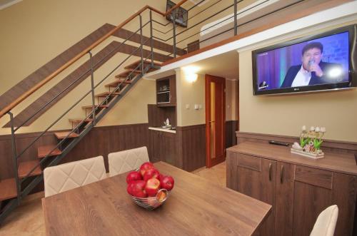 a room with a table with a television and a bowl of fruit at Várfürdő Panzió Gyula in Gyula