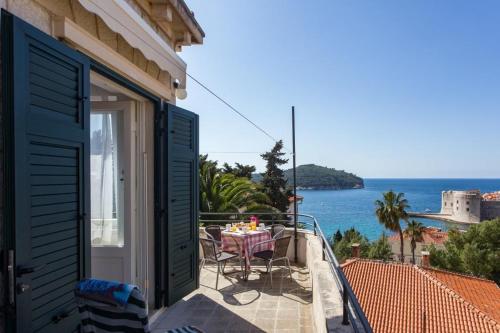 a balcony of a house with a table and chairs at Holiday Home Patricija in Dubrovnik