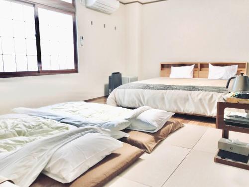 a bedroom with two beds and pillows on the floor at Daigo - Vacation STAY 07998v in Kanayama