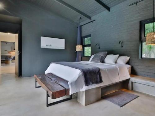 a bedroom with a large bed and a wooden bench at Chelesa by Kruger Nights in Marloth Park