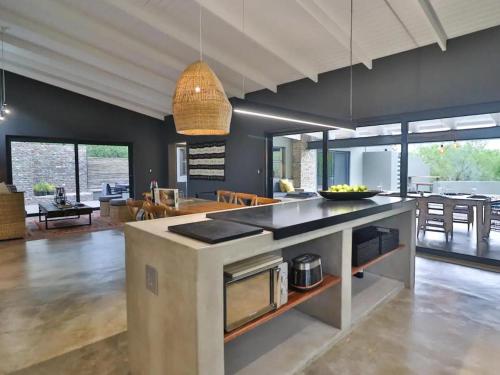 a kitchen and living room with a large island in the middle at Chelesa by Kruger Nights in Marloth Park