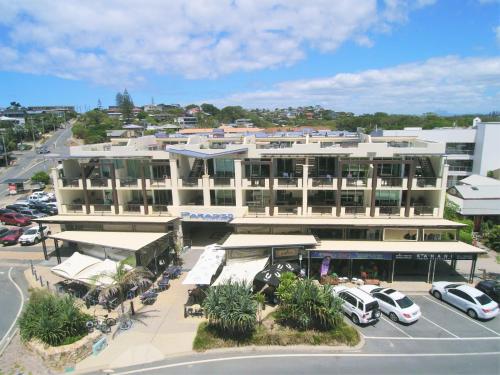 a large white building with cars parked in a parking lot at Spacious 3 bedroom apartment opposite surf club in Kingscliff
