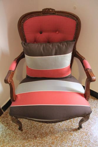a red and white chair sitting in a room at Hotel Bologna in Genova
