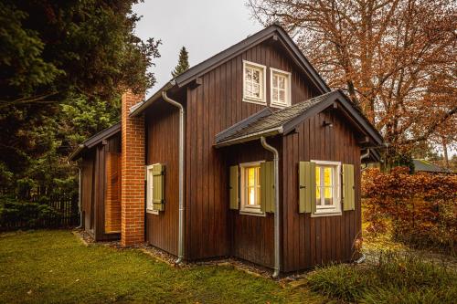 een klein houten huis met ramen en een bakstenen gebouw bij Cottage am Heiderand in Dresden