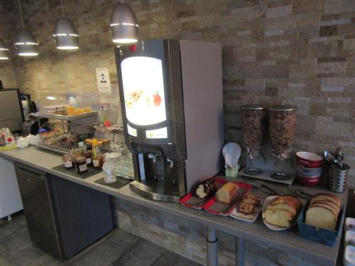 a kitchen with a counter with a coffee machine at Contact Hotel de France in Saintes