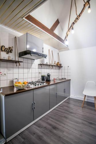 cocina con electrodomésticos de acero inoxidable y suelo de madera en Leu Cocon, en Saint-Leu