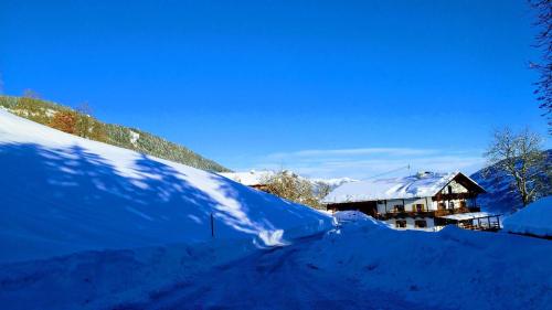 a house covered in snow next to a pile of snow at Wieshof in Kaltenbach