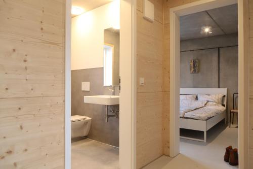 a bathroom with a sink and a bed in a room at Serviced Apartments - FeWo im Herzen Königsbronns in Königsbronn