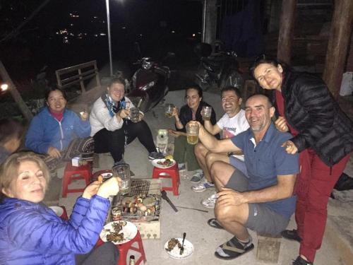 a group of people sitting around a table with drinks at ChienDe Homestay in Sa Pa