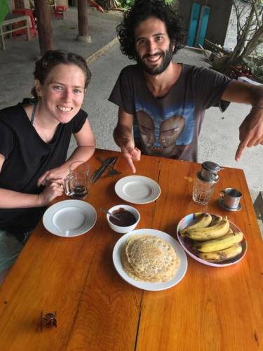 a man and a woman sitting at a table with food at ChienDe Homestay in Sa Pa