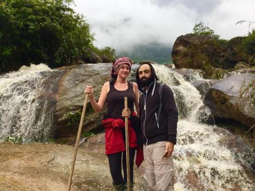 a man and a woman standing in front of a waterfall at ChienDe Homestay in Sa Pa