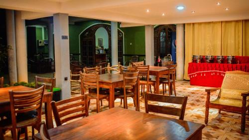 
a living room filled with furniture and tables at Gamagedara Resort in Dambulla
