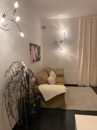 ein Wohnzimmer mit einem Sofa und einer Pflanze in der Unterkunft Mery's House casa vacanza in Fano