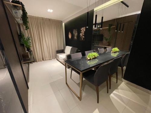 a dining room with a black table and chairs at Buenos Ayres Flats, Cabo Branco 1qto cozinha completa in João Pessoa