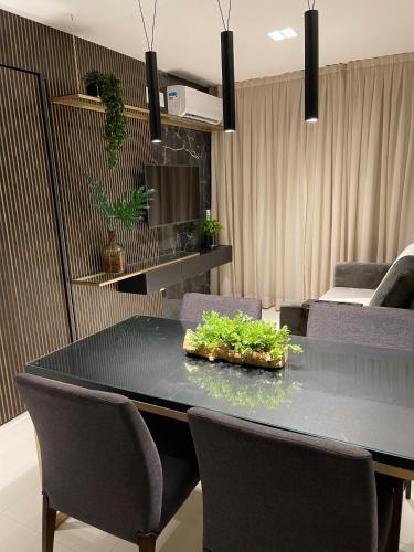 a dining room with a black table and chairs at Buenos Ayres Flats, Cabo Branco 1qto cozinha completa in João Pessoa