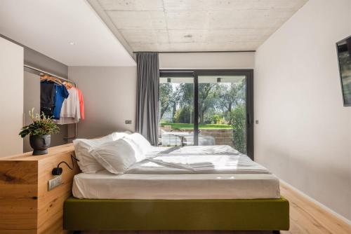 a bedroom with a bed and a window at OLEEVA Garda Living - Adults Only in Riva del Garda