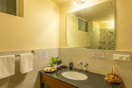 a bathroom with a sink and a large mirror at StayVista by Harmony Villa - Cosy Abode with contemporary-styled-décor in Bhīm Tāl