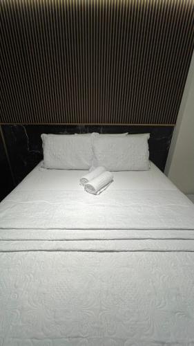 a bed with two white towels on top of it at Buenos Ayres Flats, Cabo Branco 1qto cozinha completa in João Pessoa