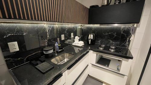 a small kitchen with a sink and a stove at Buenos Ayres Flats, Cabo Branco 1qto cozinha completa in João Pessoa