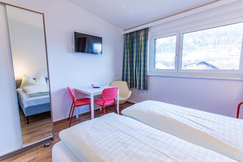 um quarto de hotel com uma cama, uma mesa e cadeiras em City Dream 2 by Alpenidyll Apartments em Schladming