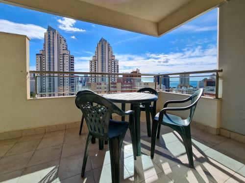 a balcony with a table and chairs and a view of the city at Apartamento Completo Torresol V in Benidorm