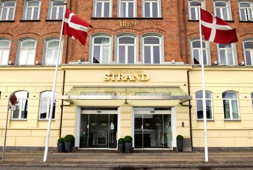 ein Gebäude mit zwei Flaggen davor in der Unterkunft Copenhagen Strand in Kopenhagen