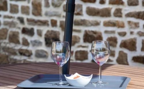 two wine glasses sitting on a tray on a table at Espace Acu-Nature in Saint-Évarzec