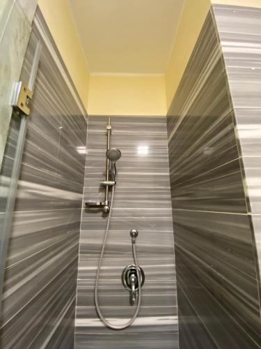 a shower in a bathroom with a metal wall at 55 Aira Hotel in Palermo