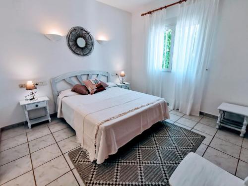 Un dormitorio con una cama y un espejo en la pared. en Villas Monte Verde -BTB, en Jávea