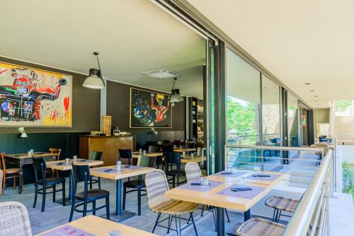 un restaurant avec des tables et des chaises en bois ainsi que des fenêtres dans l'établissement Camping Village Santapomata, à Castiglione della Pescaia