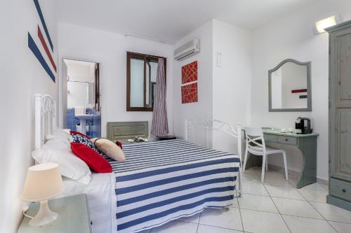 a bedroom with a bed with a blue and white striped blanket at Le Palme Di Conturrana in San Vito lo Capo
