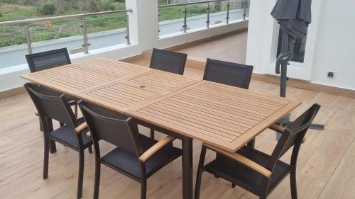 a wooden table with four chairs and a fireplace at Villa Bolati, avec piscine, jacuzzi, jardin et vue in Bonoua