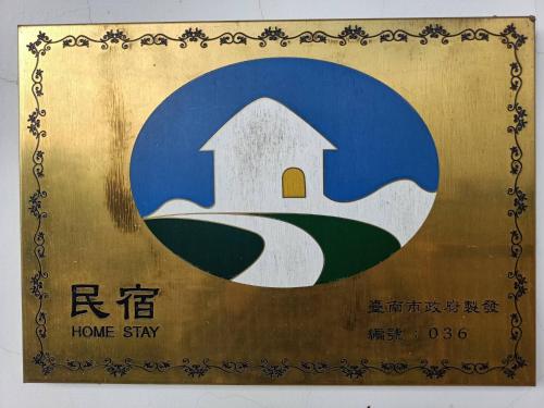 a sign for a home stay with a house on it at Zhang Yi Ya Zhu Homestay in Baihe