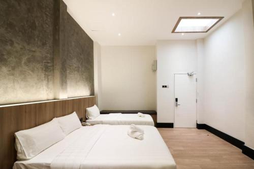 a bedroom with two beds and a window at The NINES HOTEL Malacca in Melaka