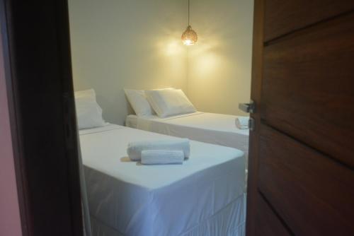 a room with two beds with towels on them at Pousada Vila Camurim in Atins