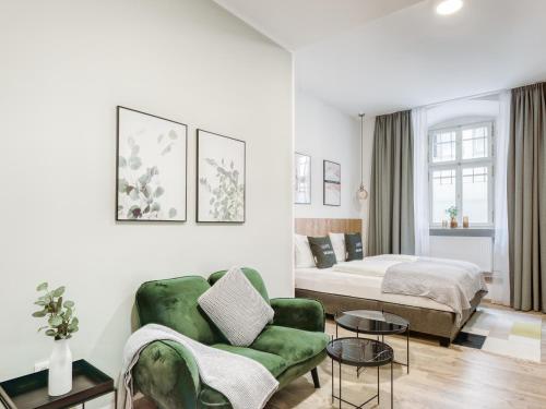 uma sala de estar com uma cama e um sofá verde em limehome Bamberg Keßlerstraße em Bamberg