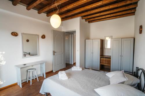a bedroom with a bed and a desk and a table at Cape Napos in Faros