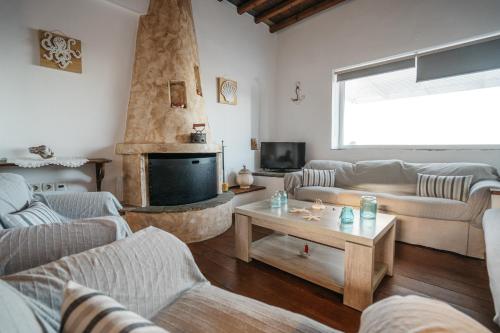 a living room with two couches and a fireplace at Cape Napos in Faros