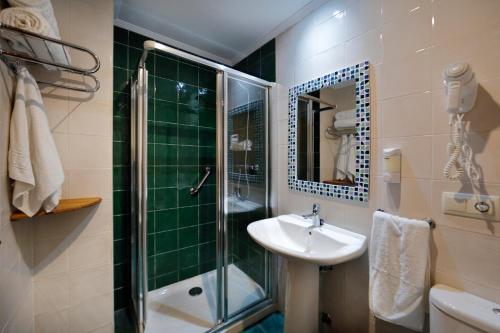 y baño con ducha acristalada y lavamanos. en Hotel Rural Montesomao, en Somado