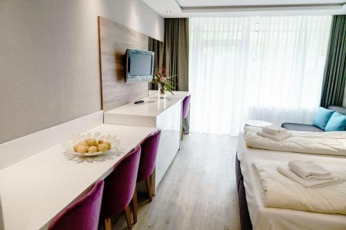 ein Hotelzimmer mit einem Tisch, Stühlen und einem TV in der Unterkunft Haus am See Luxury HS 223 B in Hahnenklee-Bockswiese