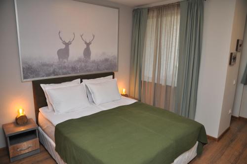 1 dormitorio con 1 cama con 2 pinturas de ciervos en la pared en Hashtag Studio Borovets, en Borovets