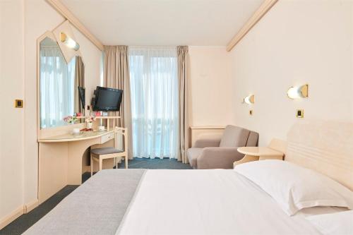 a hotel room with a bed and a living room at Hotel Gran Vista Plava Laguna in Poreč