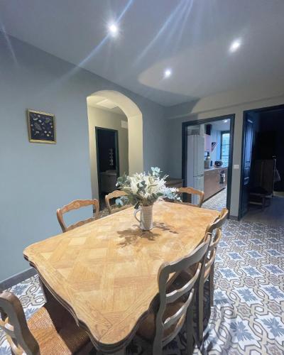 une table de salle à manger avec un vase de fleurs dessus dans l'établissement CASADELLA - Casa Calittu, à Bastia