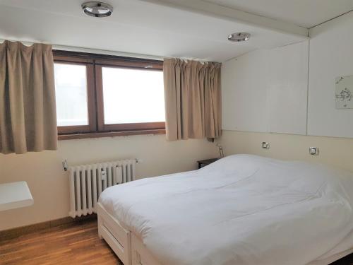 a bedroom with a white bed and a window at Ski slopes apartment in Sestriere