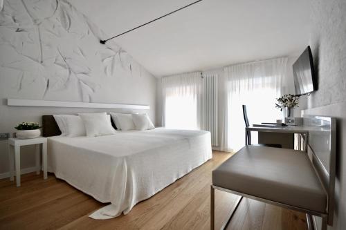 a white bedroom with a white bed and a window at Rubiera Relais B&B in Rubiera